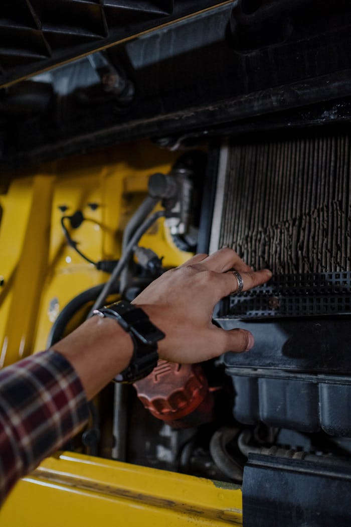 Close-up of a hand inspecting a truck's engine air filter. Mechanical maintenance concept.